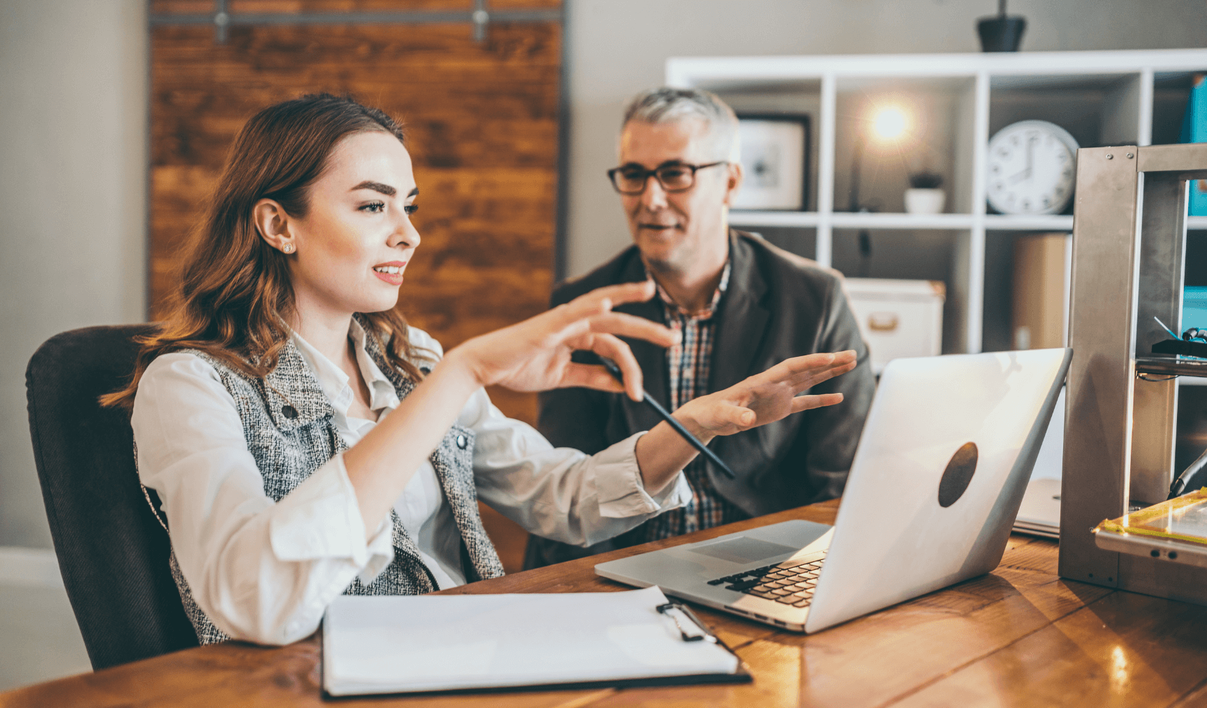 a woman explaining something on a laptop to an older man