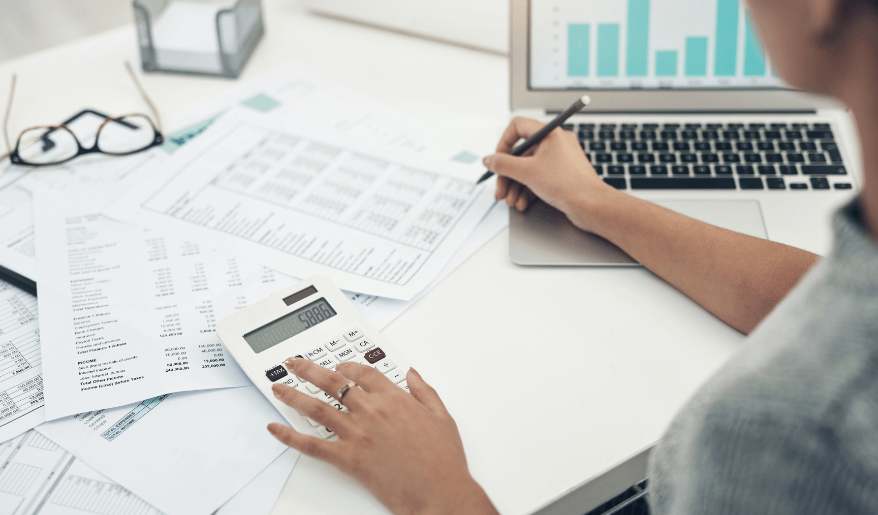 woman at her work desk using a calculator
