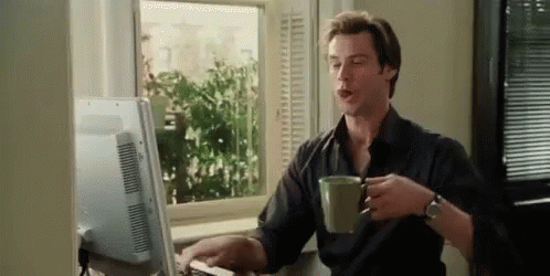 Jim Carrey drinking coffee in front of the computer