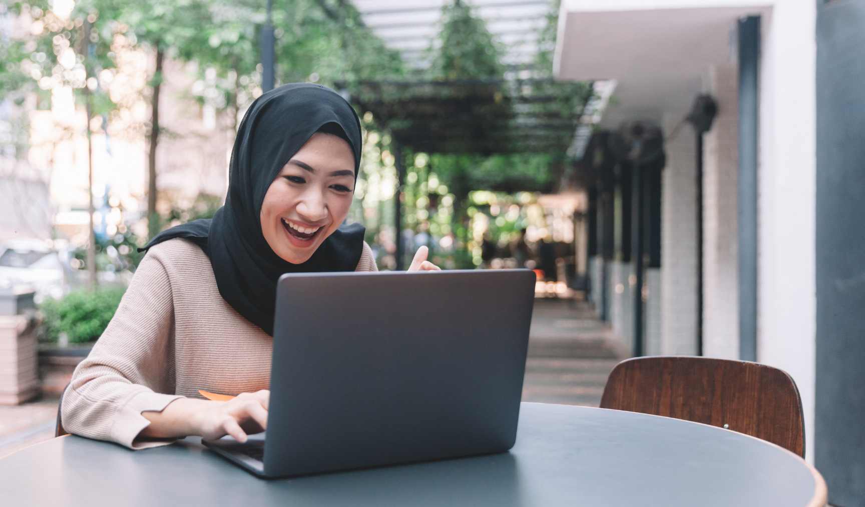 woman typing on laptop in an outdoor area