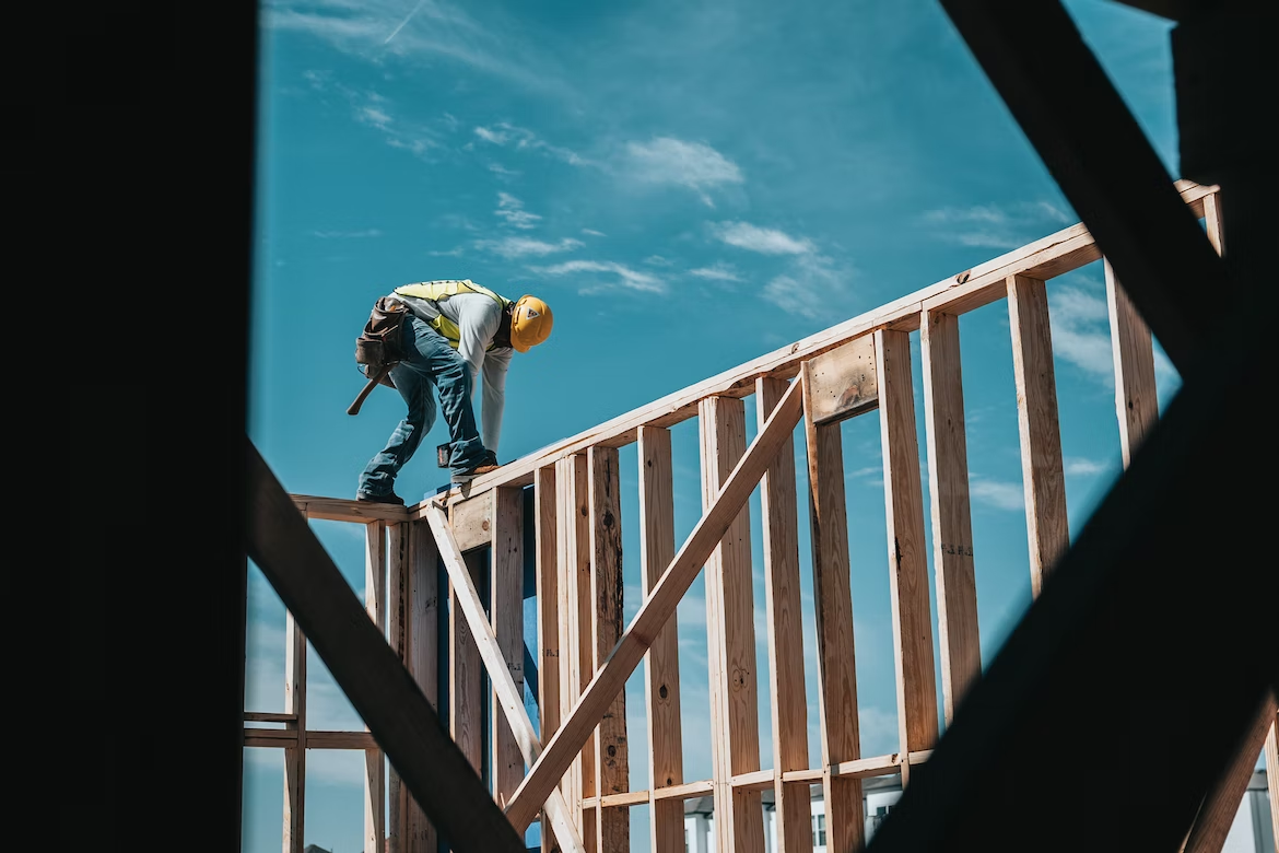 construction worker standing atop a wooden structure