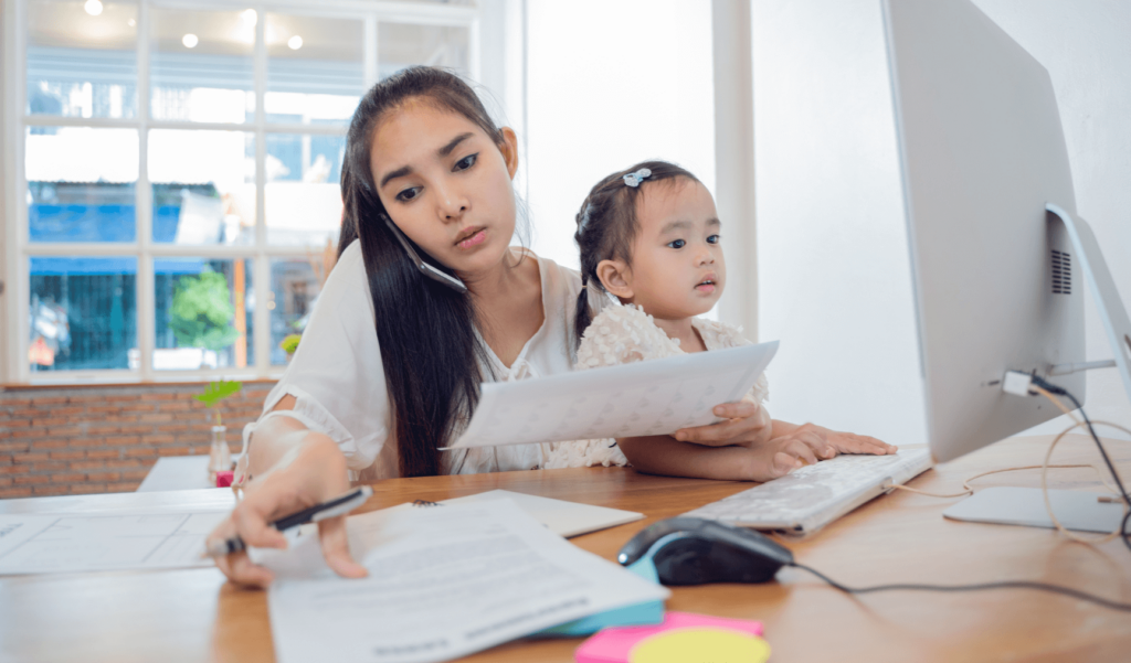 a woman working while holding her child