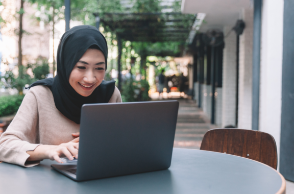 woman typing on her laptop while smiling