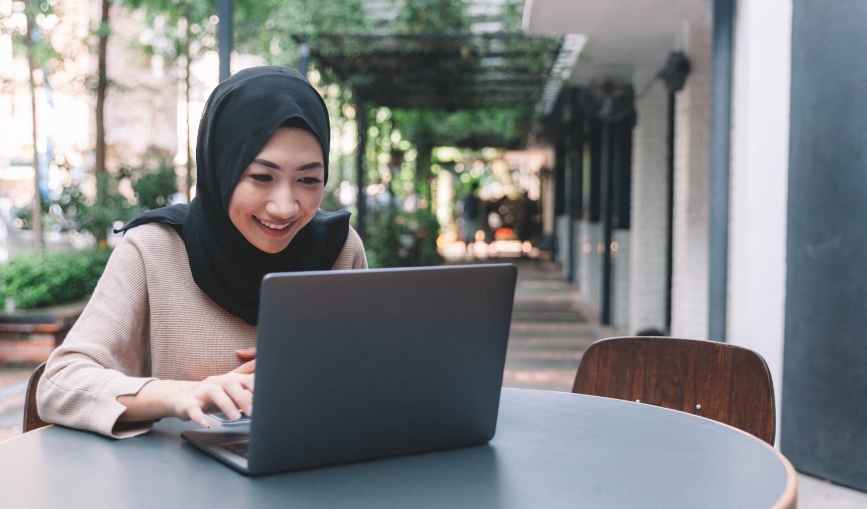 woman typing on her laptop while smiling