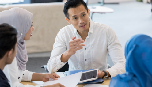 guy holding a tablet while chatting with colleagues