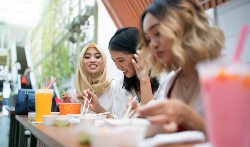 friends chatting while eating outside at a hawker