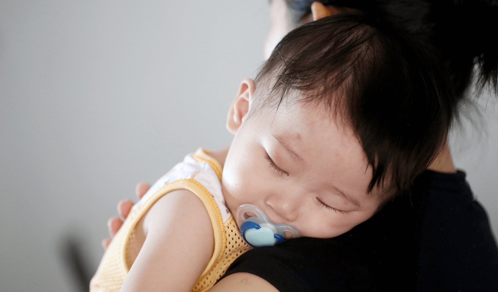 sick baby being carried by his mum 