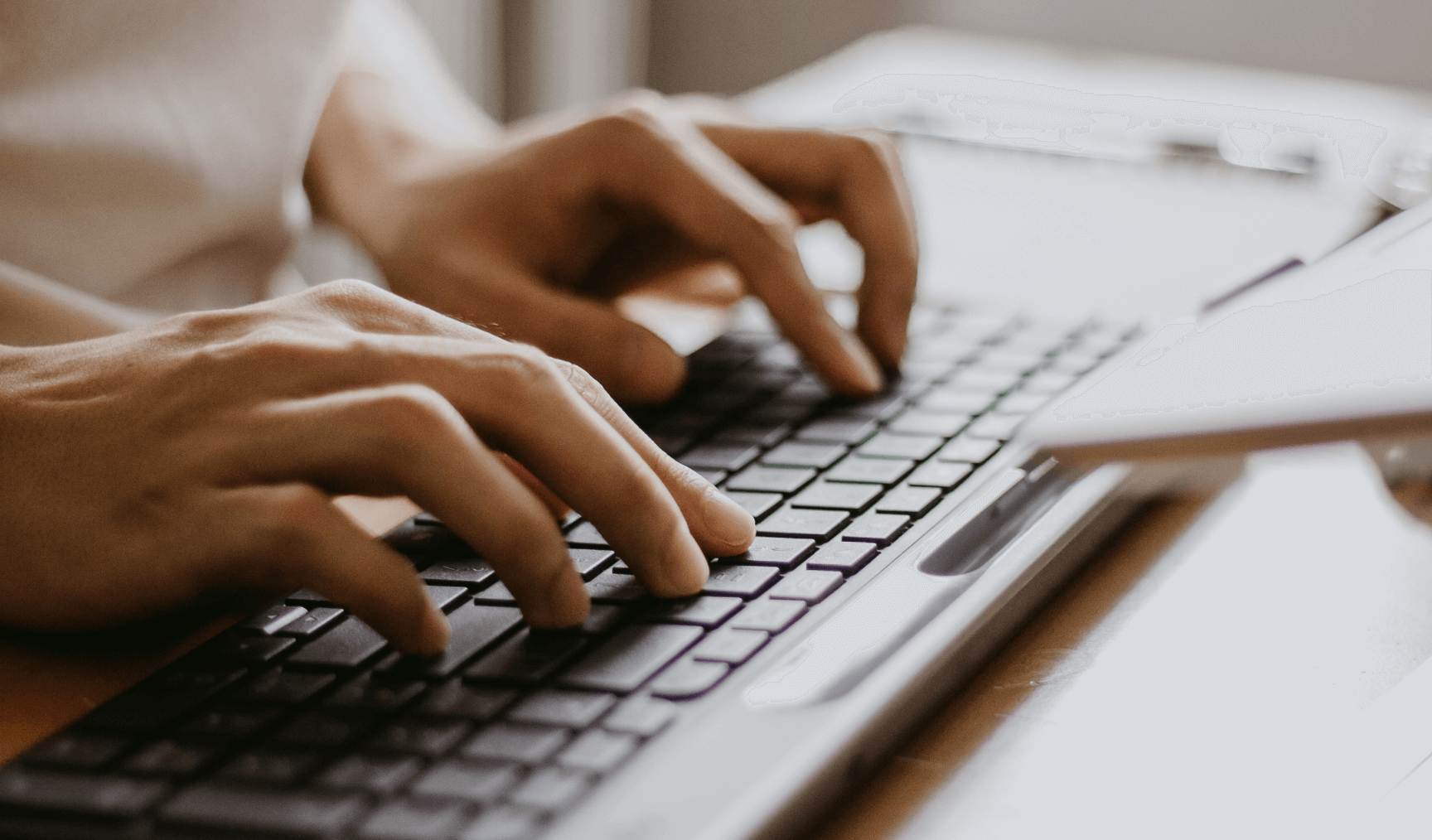 close up of a woman's hands typing on a keyboard