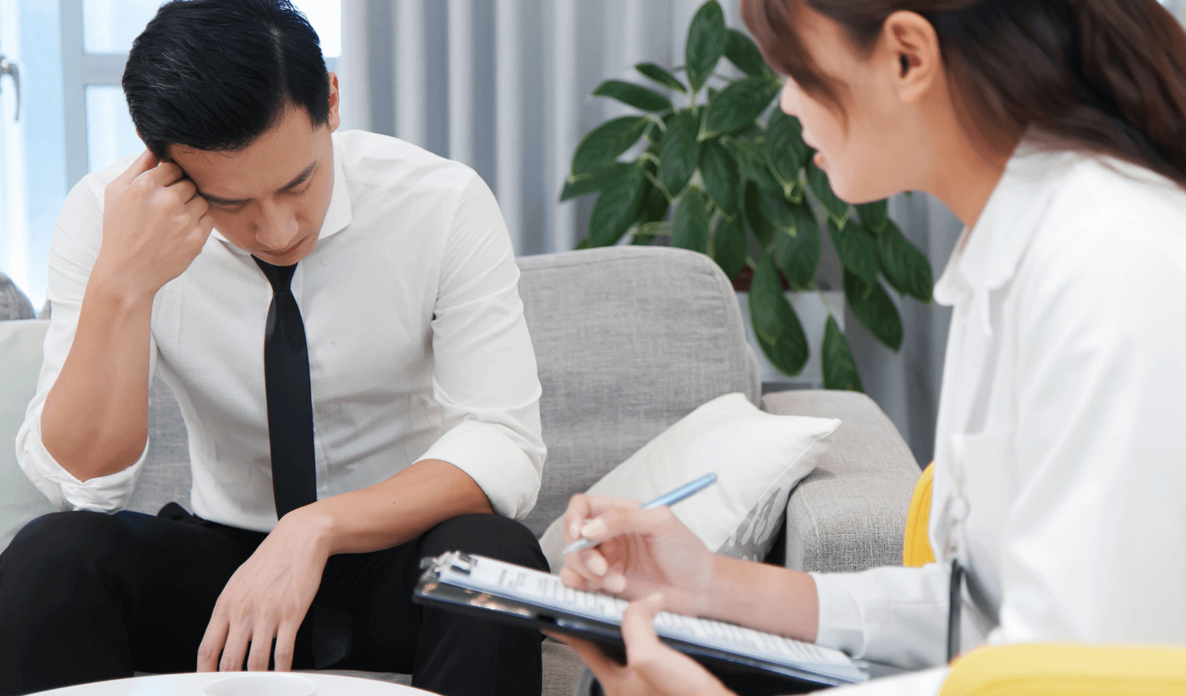 male officer worker talking to a counsellor with his head down