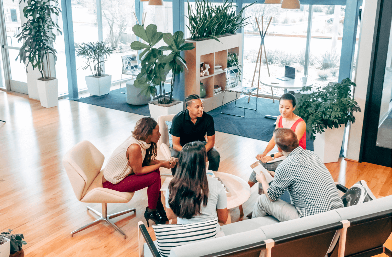 colleagues gathered in a circle chatting in the office