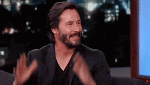 Keanu Reeves rubbing his hands together in excitement, saying 'I can't wait for this!'