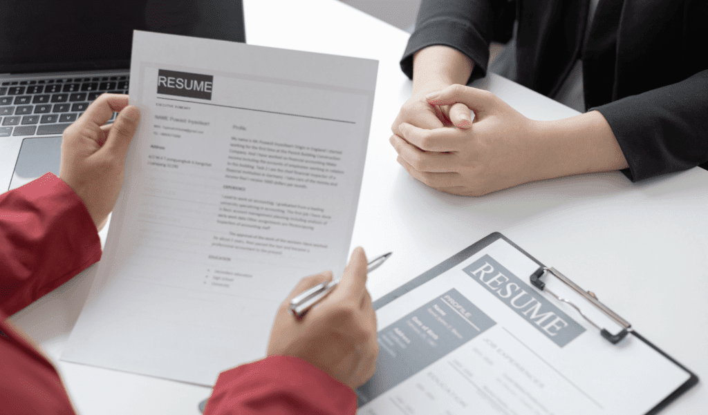 two people having an interview where one person is looking at the other person's resume