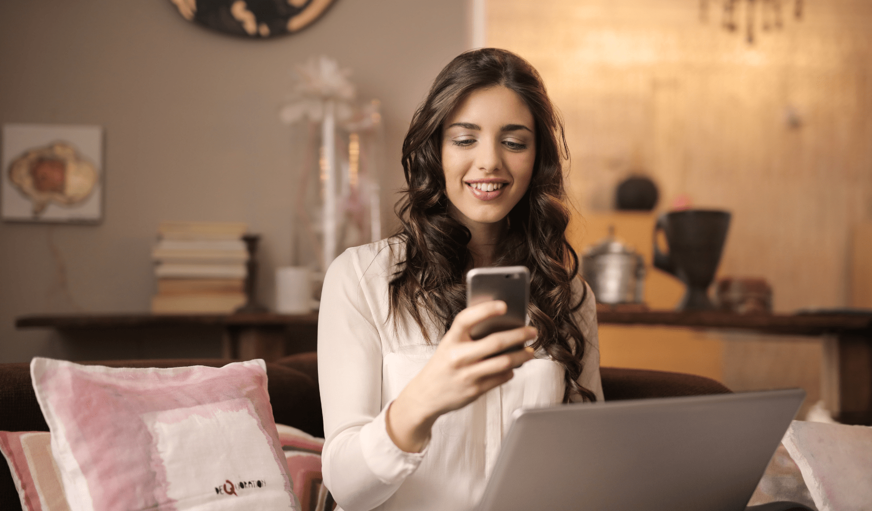 Woman looks at her phone smiling in an office