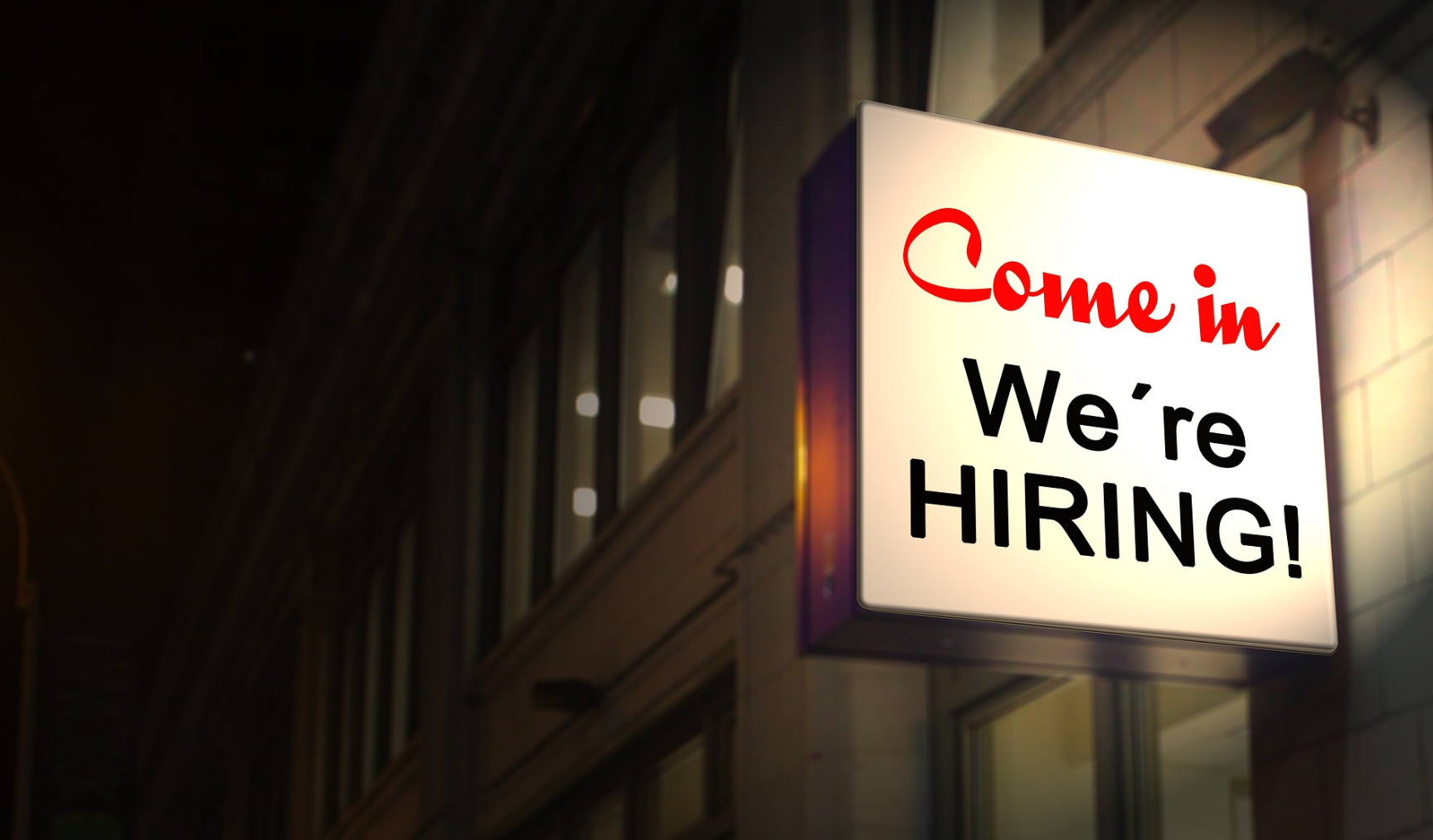Sign outside a building showing the text 'come in, we're hiring'