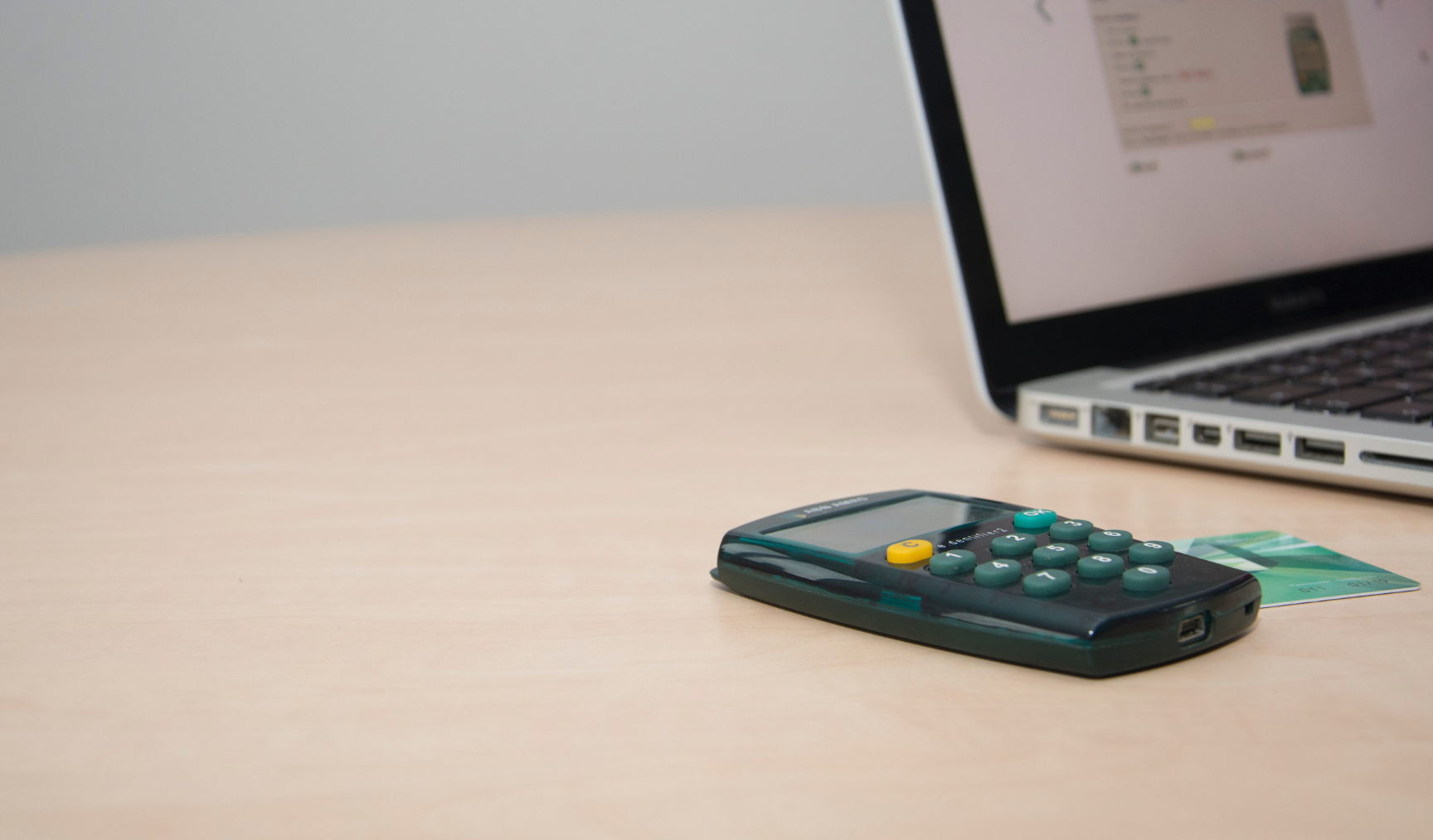 A calculator sitting next to a laptop on a table