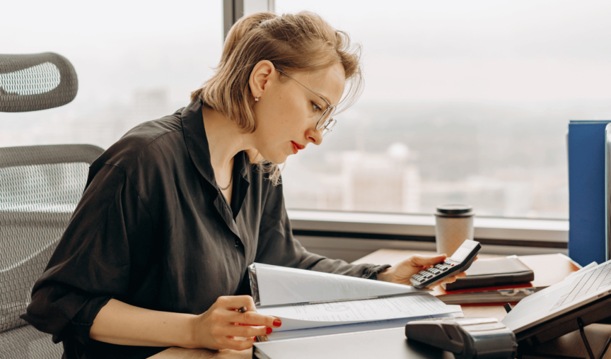 Woman using a calculator and manual calculations.