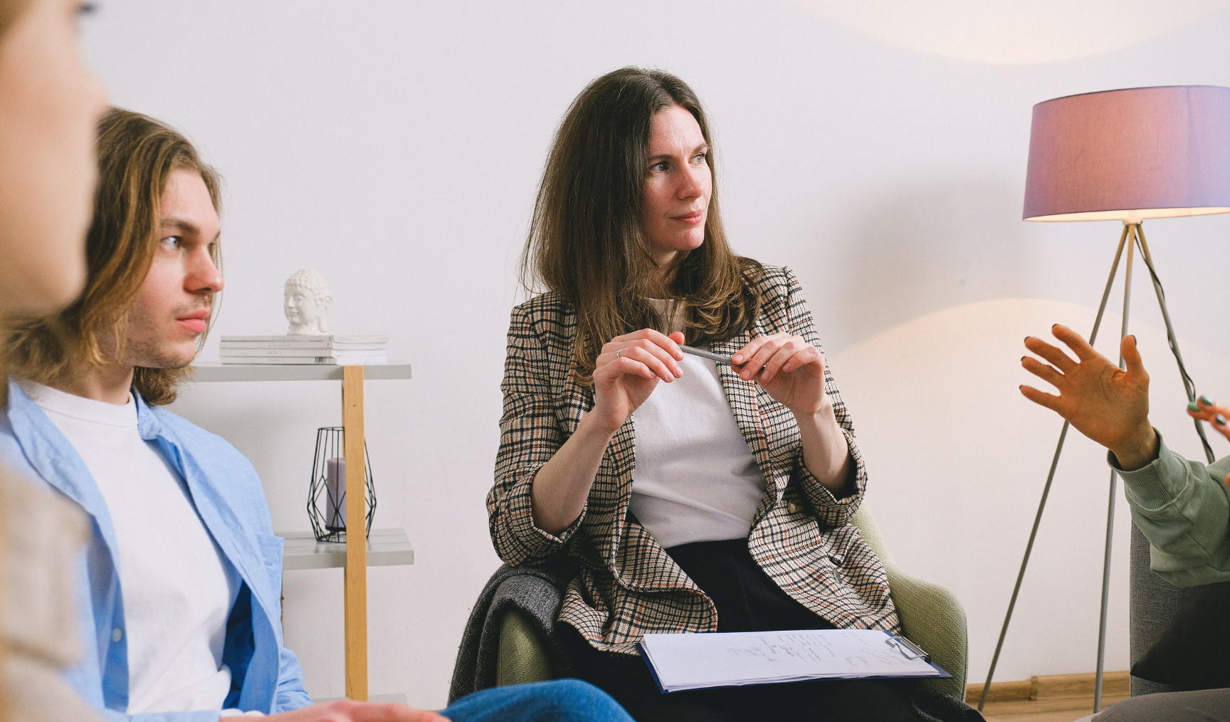 Woman sits at meeting, listening intently with a serious expression