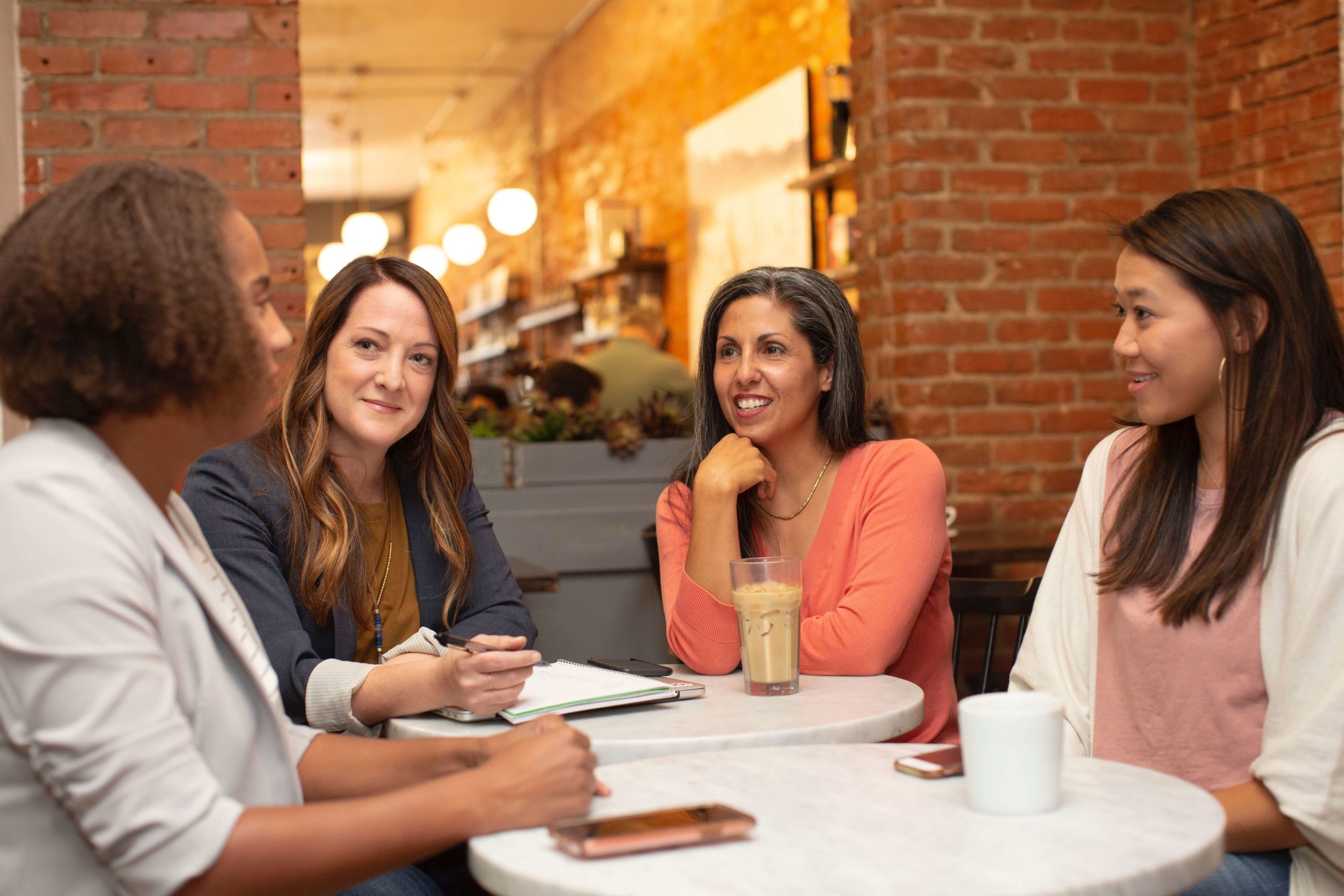 group of women talking to each other in a cafe