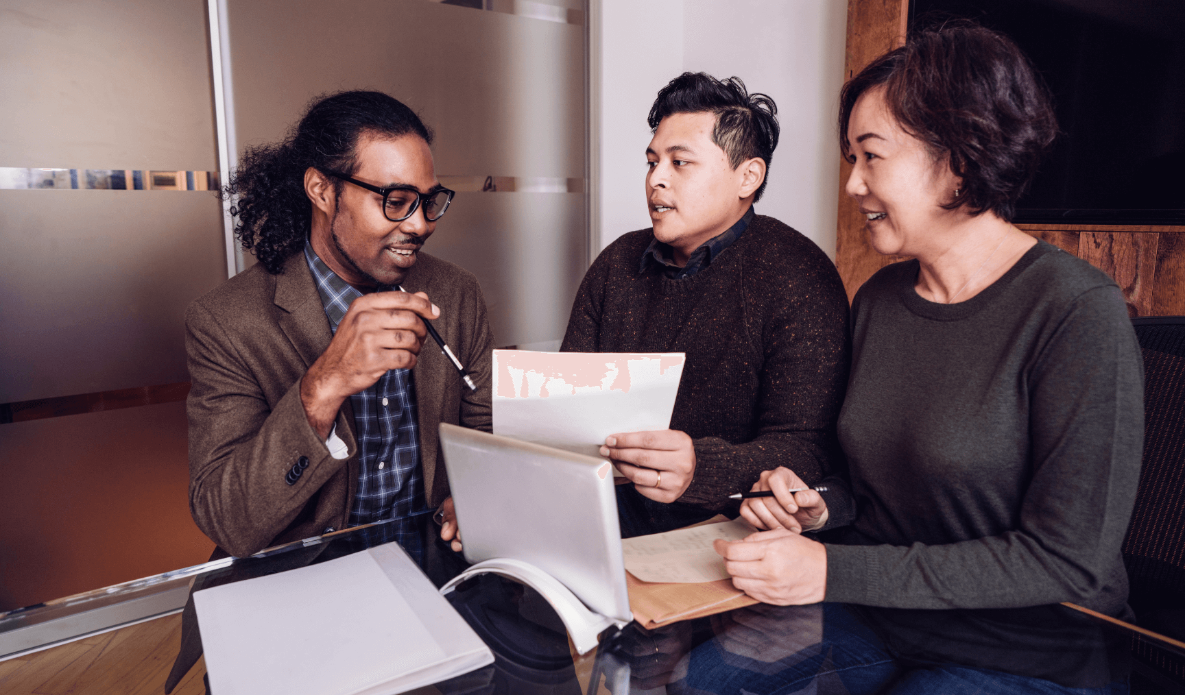 three people having a group discussion at the office