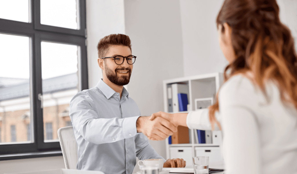 an interview candidate shaking hands with the hiring manager