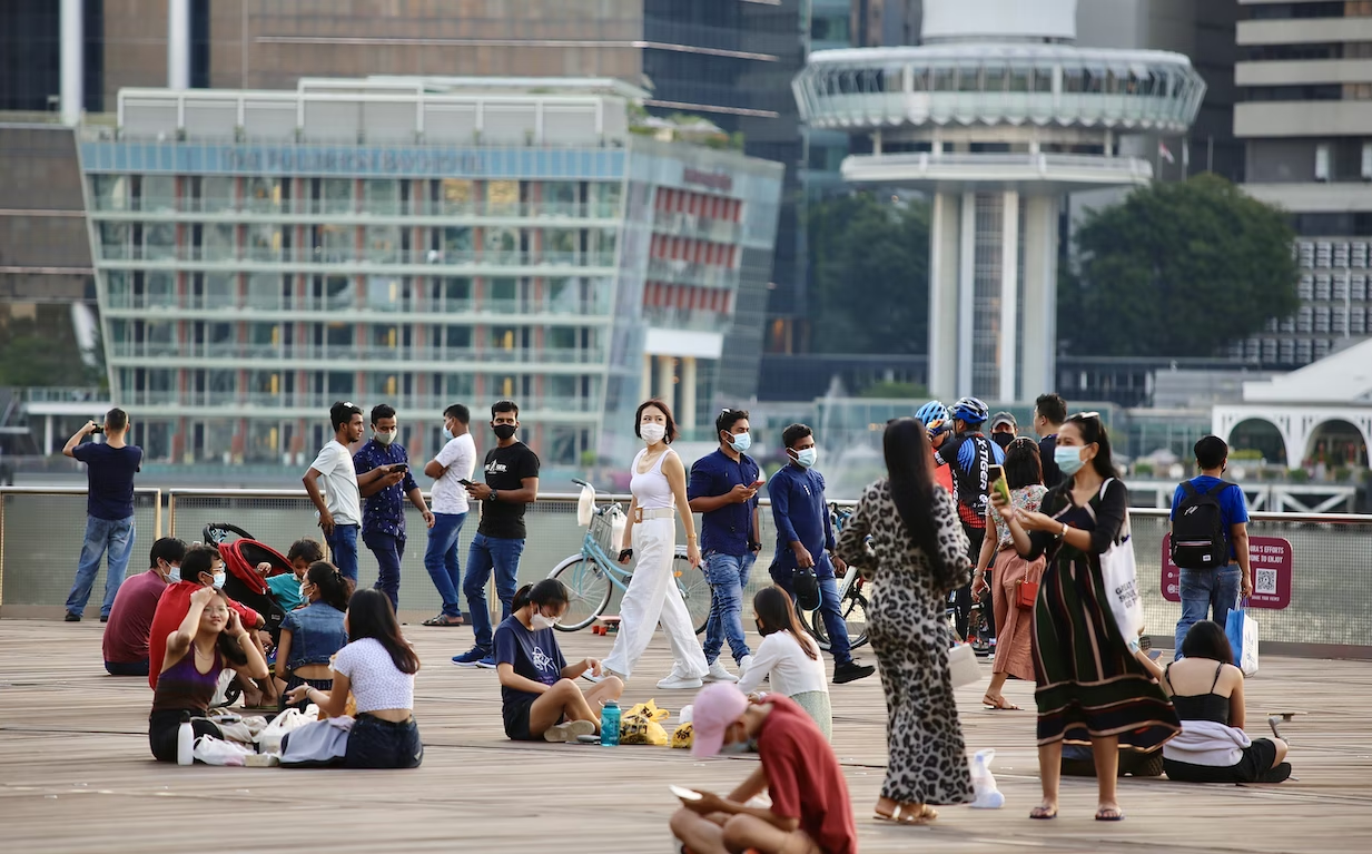 people walking around or sitting down leisurely at Marina Bay Singapore