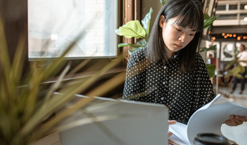 image of an employee at her desk looking through some papers