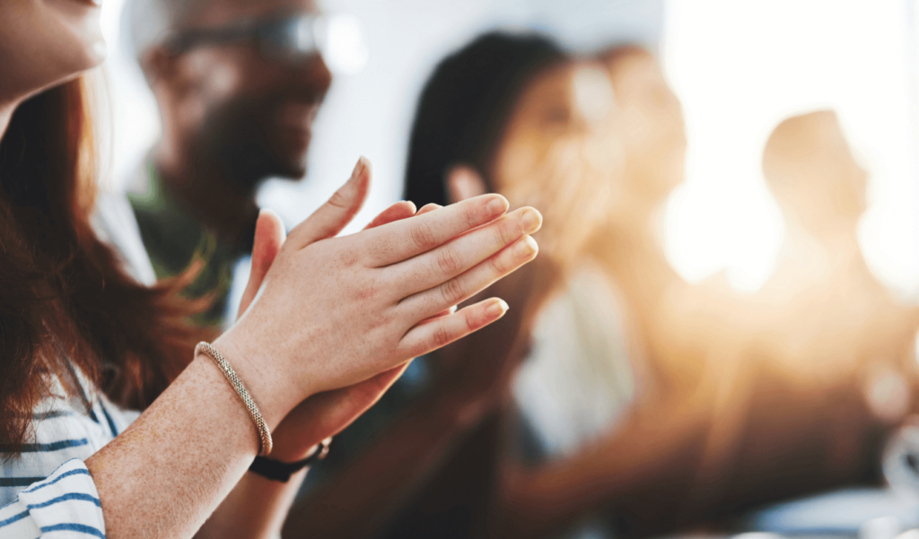 a woman clapping her hands in a group of people