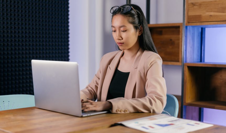 woman seated at her desk typing away on her laptop