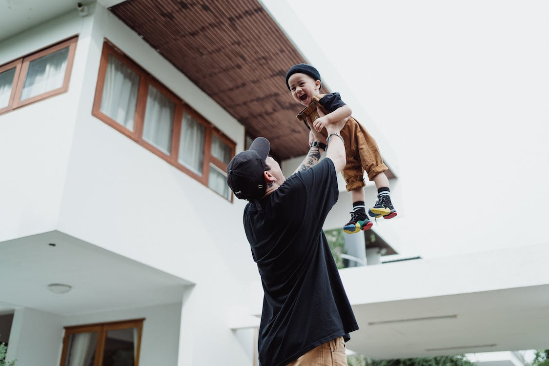 dad lifting his kid to the sky while playing