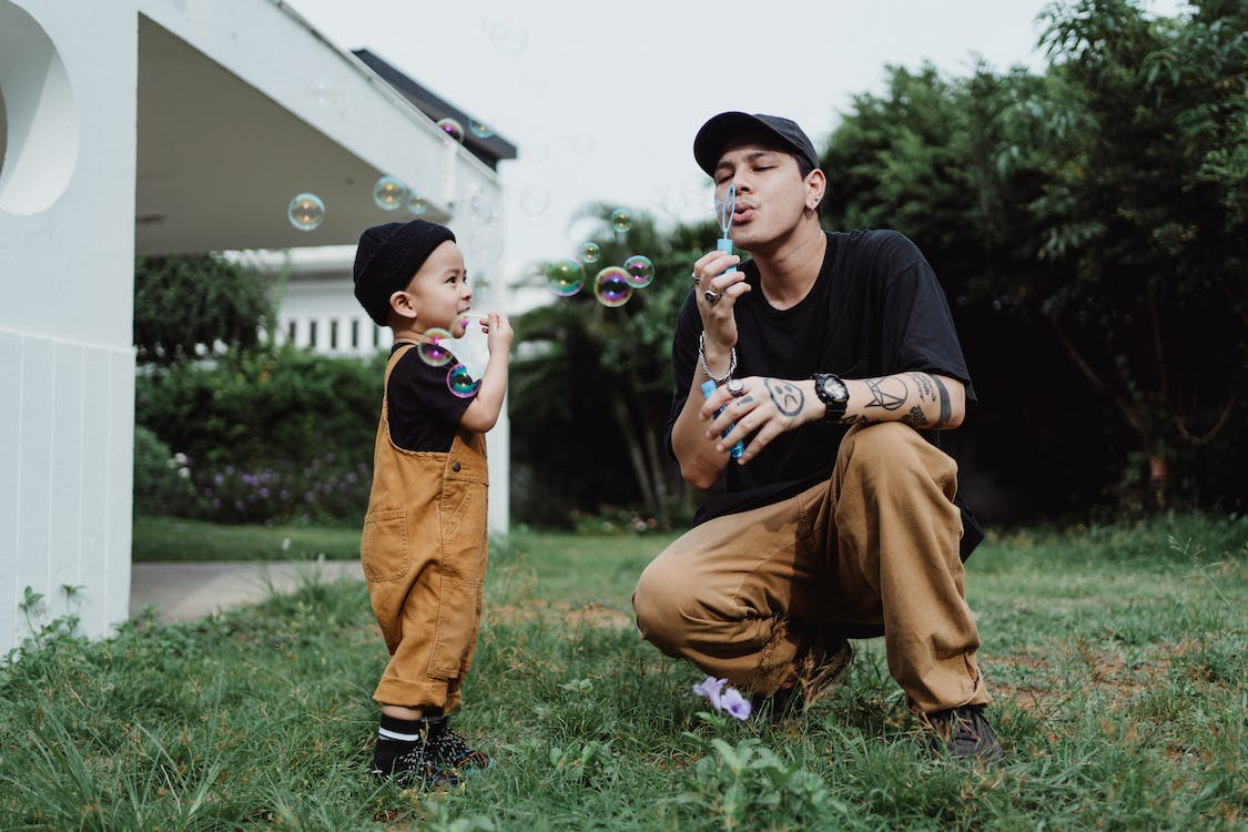 dad playing with his kid and blowing bubbles