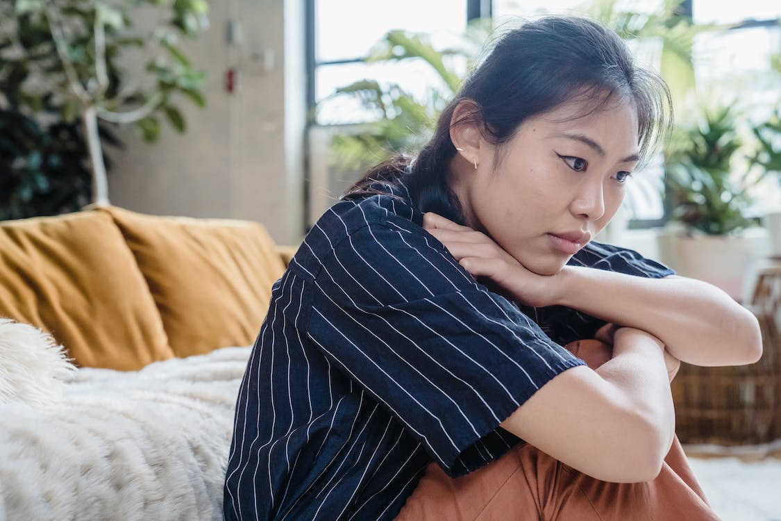 woman sitting on the floor staring into space