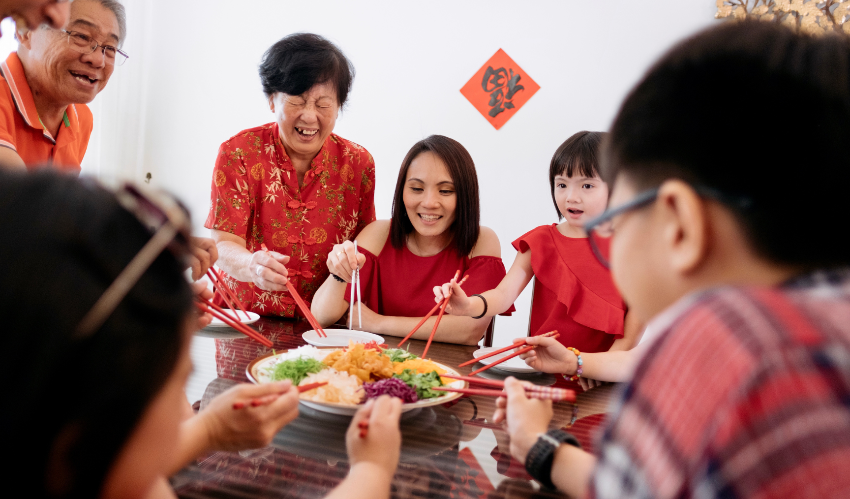 chinese family gathered around the table celebrating lunar new year