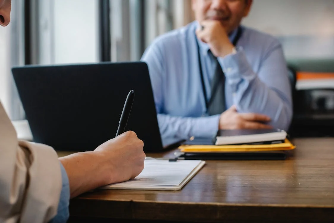 group of diverse employees laughing at something on the ipad