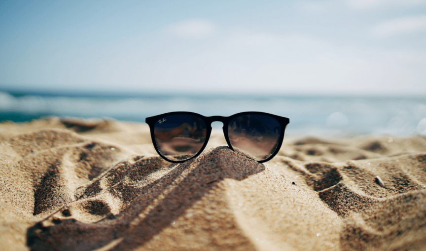 sunglasses on a beach - employers encourage annual leave
