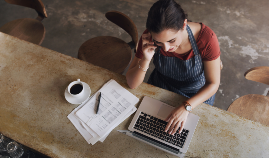 woman talking on the phone while using her laptop