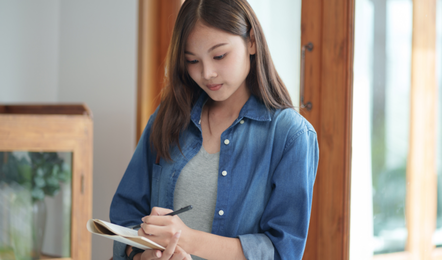 woman writing on her notepad