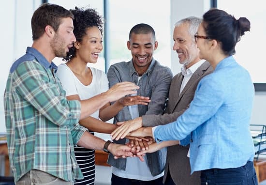 A team of differently aged people putting their hands in the middle