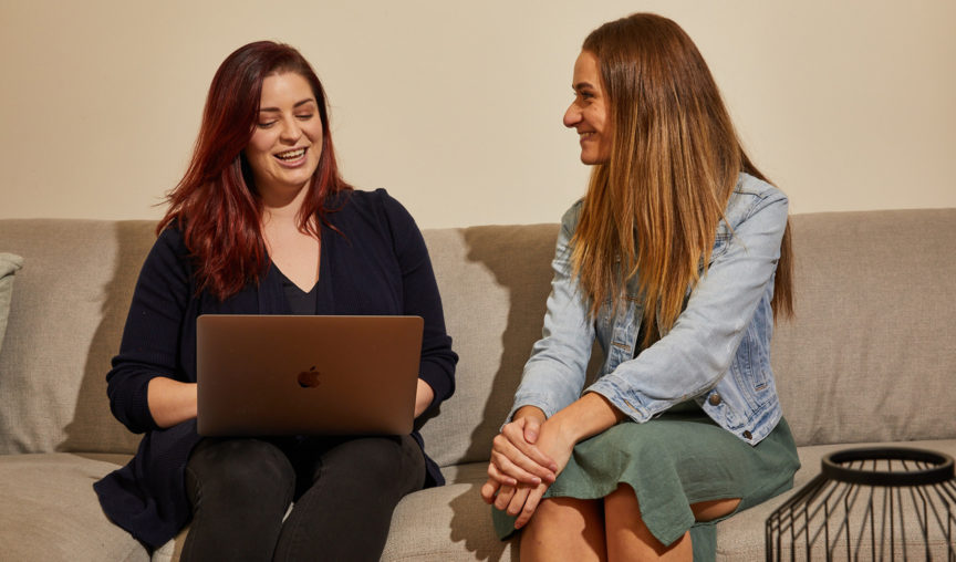 two women chatting over a laptop