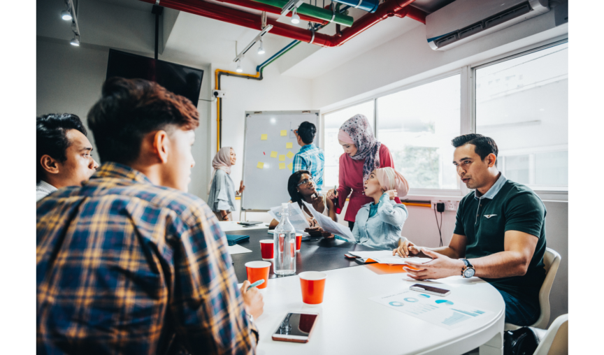 A team working at a round table on a project.