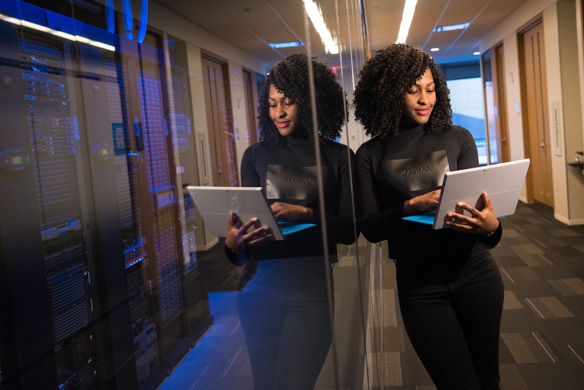 woman leaning against server with an open laptop